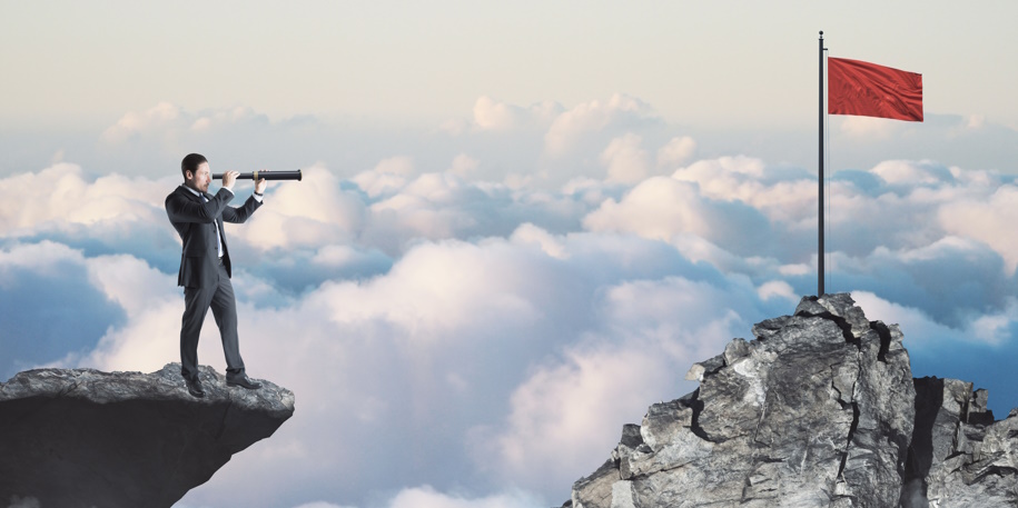 Abstract image of businessman with telescope looking into the distance while standing on edge of cliff, mock up place on sky with clouds background, red flag. Success, challenge, future and growth concept