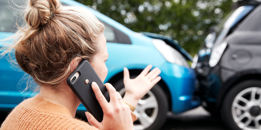 woman on the phone by a car accident